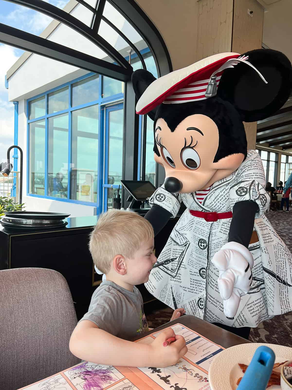 Minnie Mouse hugging kid at Topolino's Terrace character brunch at Riviera Resort