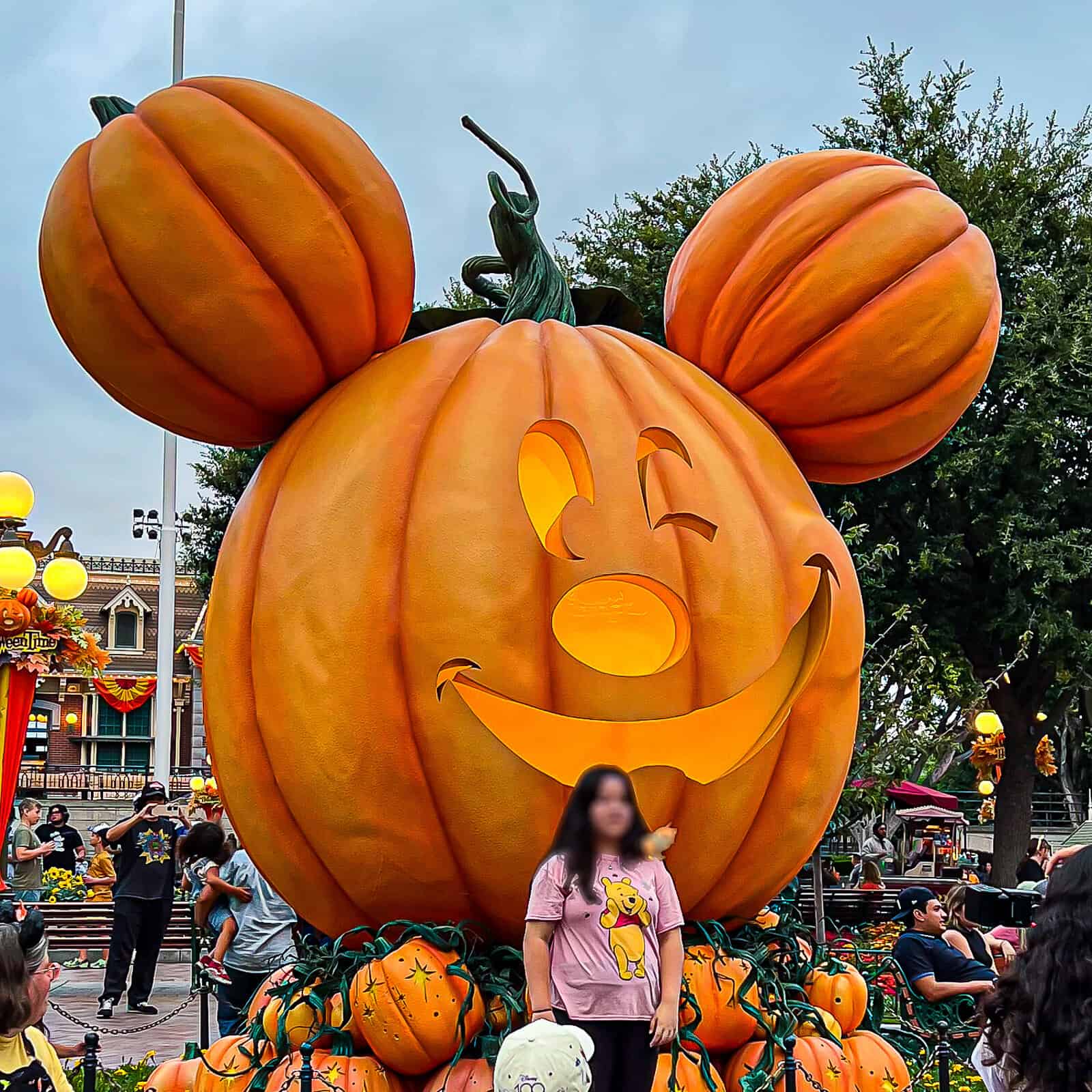 Demonstrating Travelers Arriving When Halloween Starts at Disneyland at the Entrance to the park with pumpkin Mickey Mouse decor 