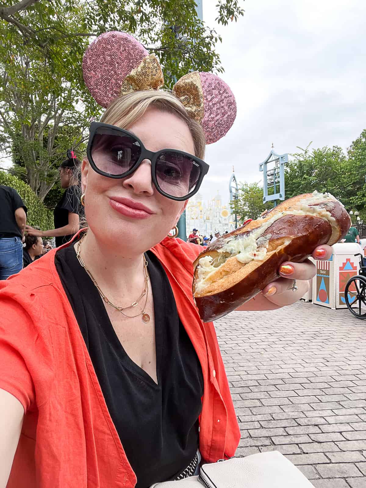 Disneyland food blogger with parmesan cheese pretzel in Disneyland park