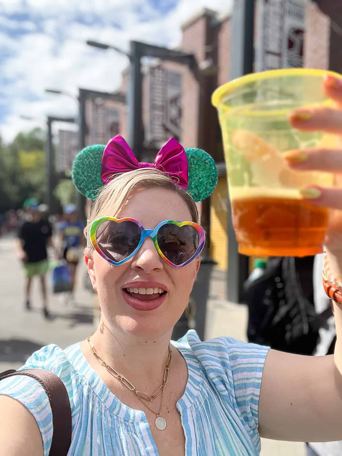 Jenna Passaro Disney blogger wearing a cute dress to Disneyland with heart sunglasses and Mickey ears